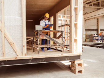 Male builder writing on clipboard at construction site
